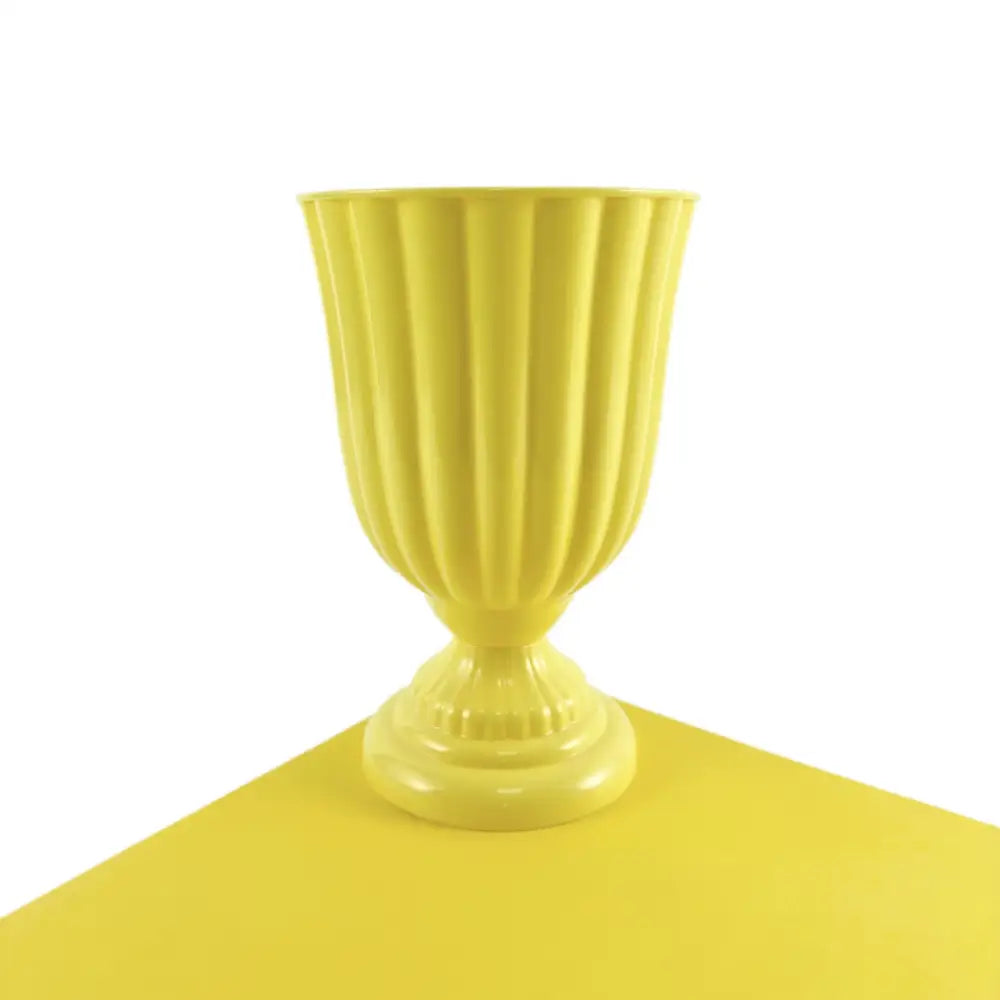 A vibrant yellow ribbed ceramic DecorBites™ mini flower arrangement vase with classic urn shape and fluted base