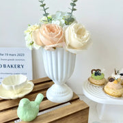 DecorBites™ mini flower arrangement vase with white ceramic fluted pedestal base holding peach cream roses and greenery