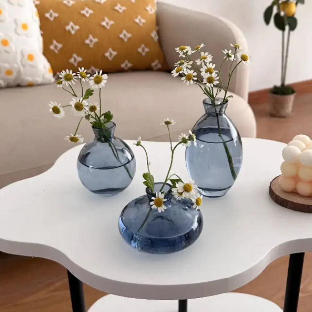 DecorBites™ mini glass flower vases in translucent blue holding delicate white daisies for home decor