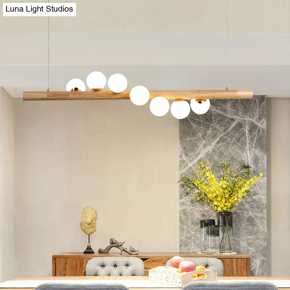 DecorBites minimalist cream glass LED pendant light with wooden bar and white globes ball island pendant for restaurants