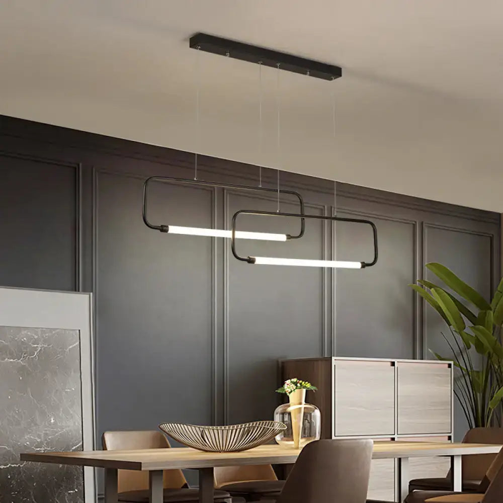 Modern black rectangular pendant lights with sleek minimalist design hang above dining room table by DecorBites™