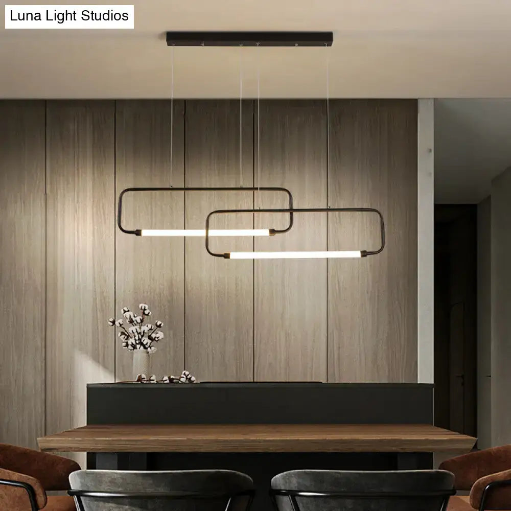 Modern black rectangular DecorBites™ LED pendant lights with minimalist design hang above a wooden dining room table