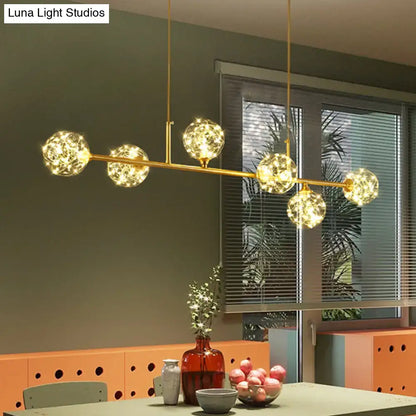 Gold-toned DecorBites™ minimalist LED pendant ceiling light with five glowing clear glass sphere shades suspended by rods