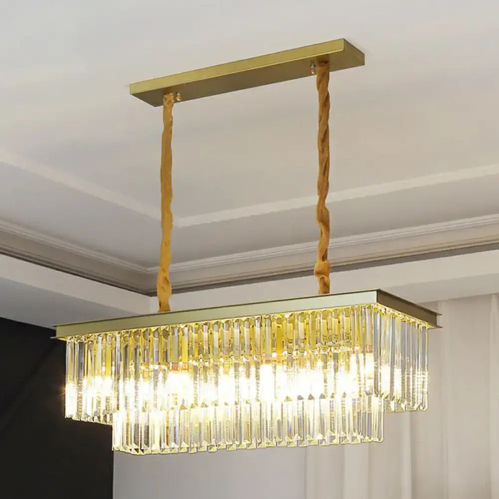 Gold-toned rectangular pendant light with cascading clear prismatic crystal prisms and twisted rope suspension by DecorBites