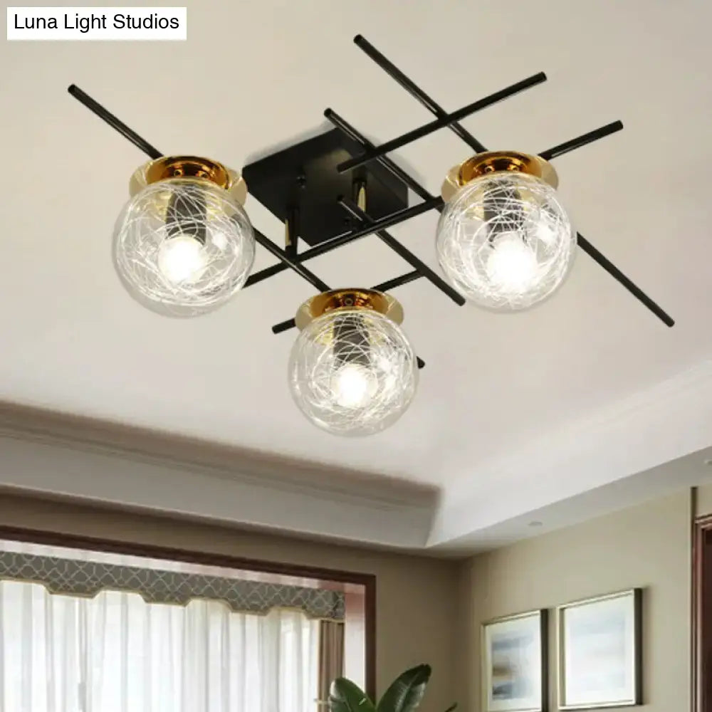 Modern black metal semi-flush ceiling light with three clear smoke gray glass globes and gold-toned rims for bedroom use