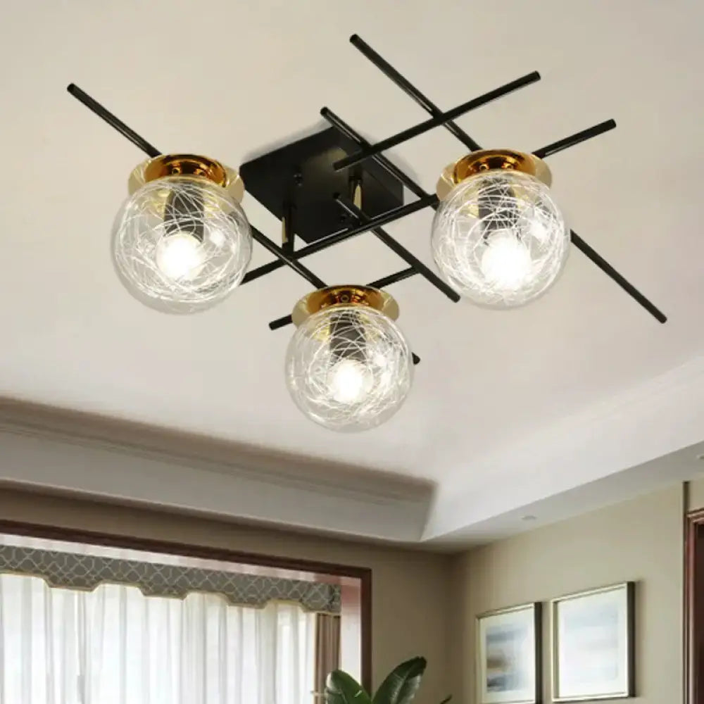 Modern black metal ceiling fixture with three clear smoke gray glass globes and gold metallic rims for bedroom lighting
