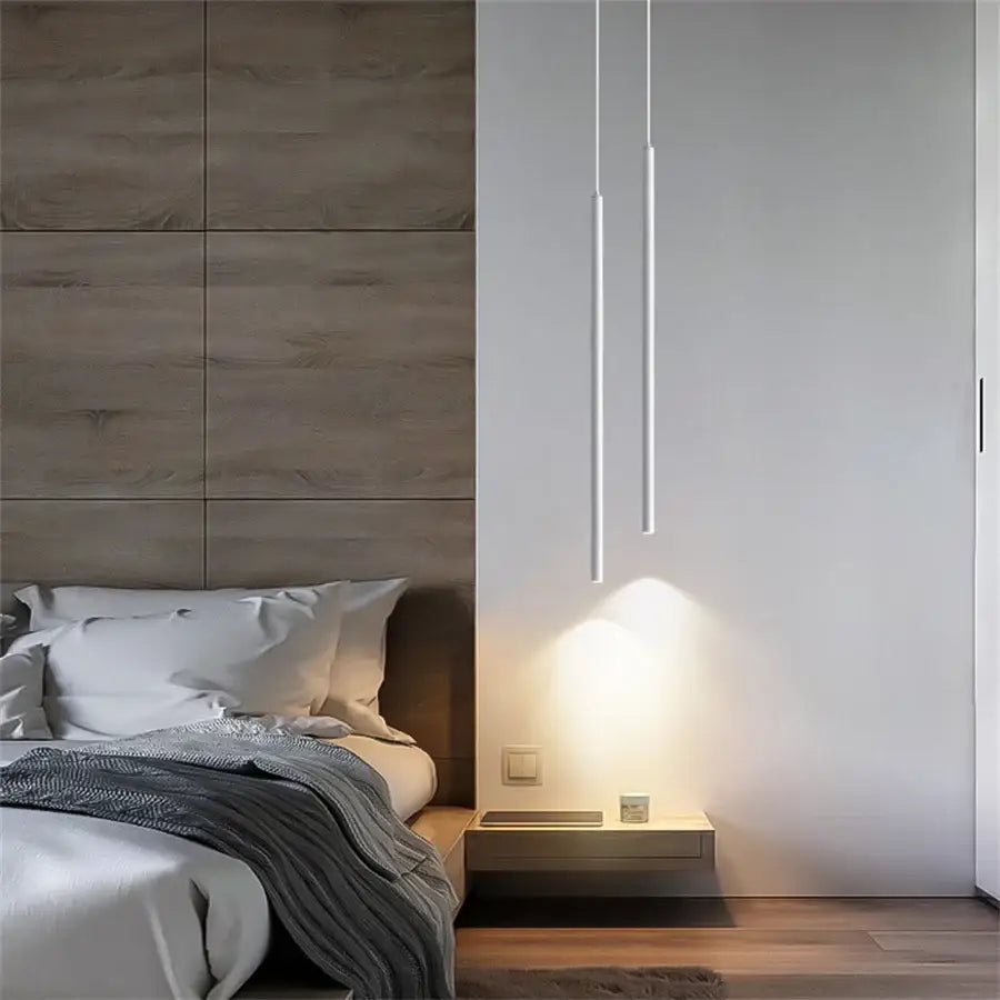 Minimalist white cylindrical decorbites™ modern 2cm led pendant lights hang above a floating nightstand casting warm illumination