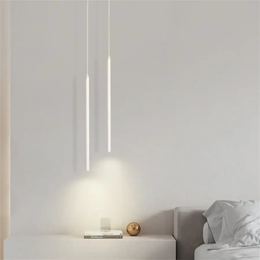 Two minimalist white DecorBites™ modern 2cm led pendant lights hang vertically casting soft glow on kitchen island wall