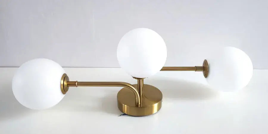 Gold-toned table lamp with three frosted acrylic ball shades in a modern branching design for stylish ceiling light use
