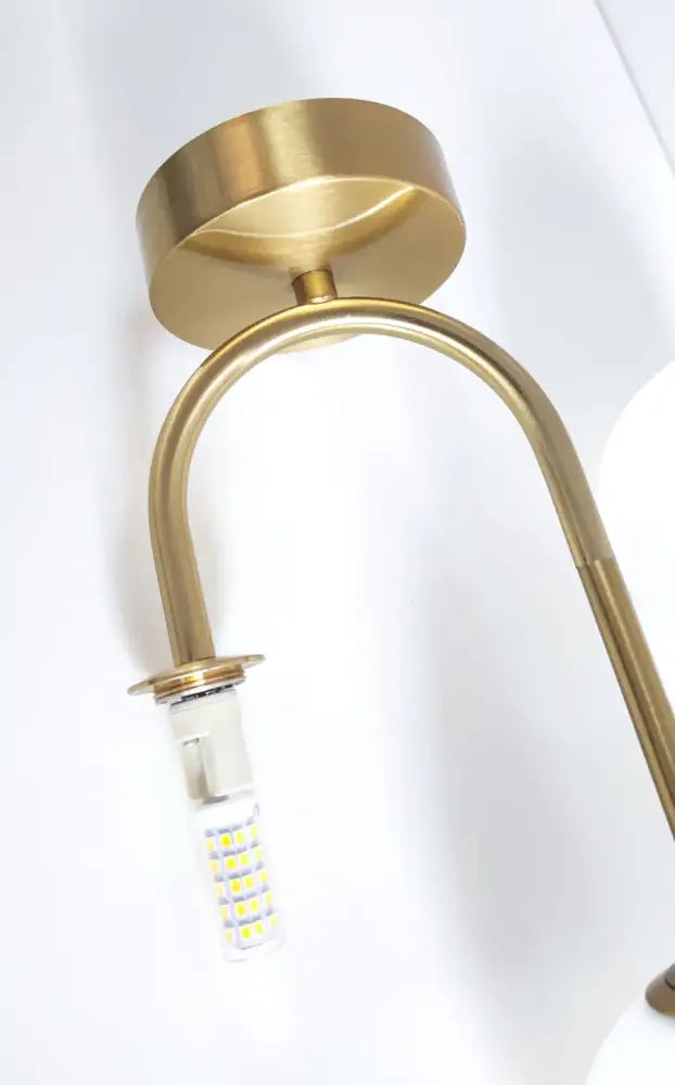 A sleek brass wall sconce with a modern design complements the decorbites acrylic ball ceiling light for home use