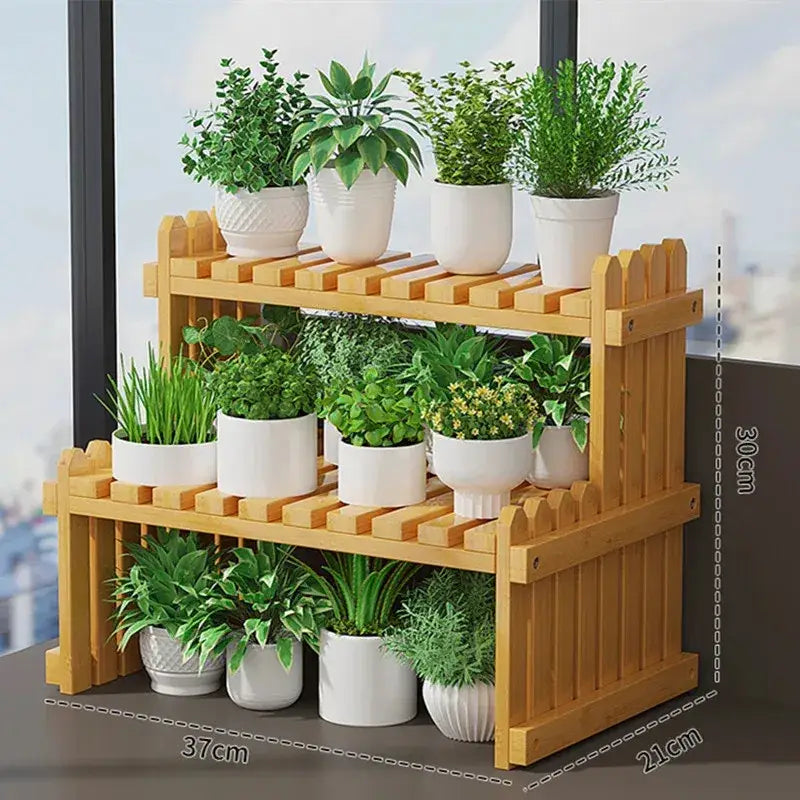 Light brown bamboo two-tier plant display stand with picket fence design holding white ceramic pots with green plants