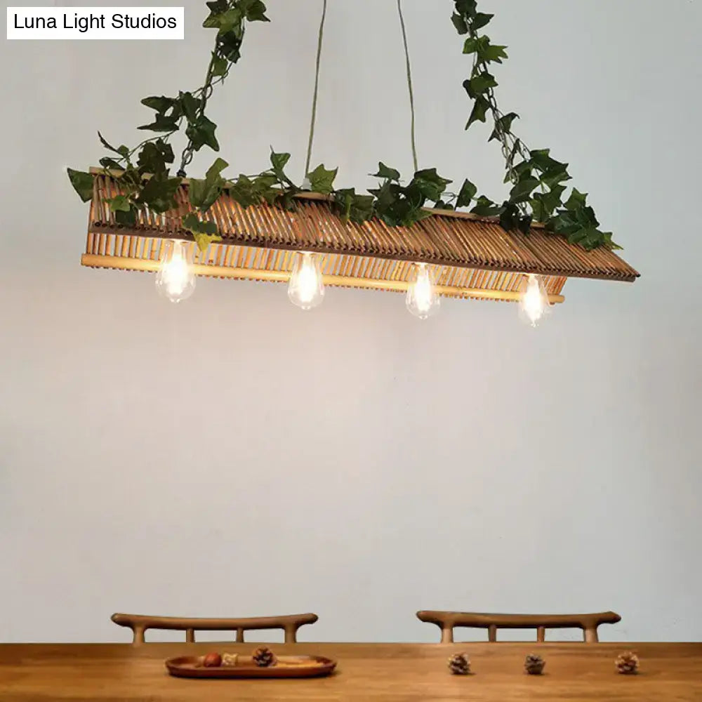 Rattan rectangular pendant light with hanging green ivy and four exposed bulbs in a decorbites triangle roof fixture