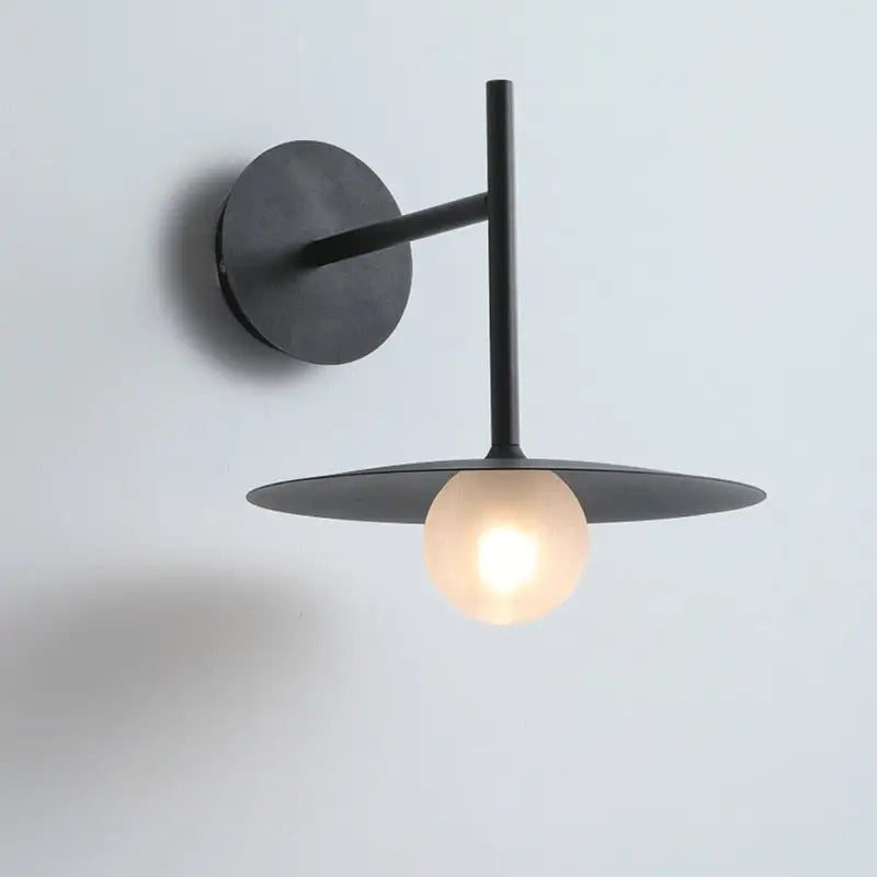 DecorBites™ modern bedside wall light in black matte finish with circular base and frosted glass globe bulb