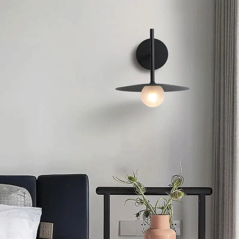 DecorBites™ modern black minimalist bedside wall light with circular base and flat disc shade housing warm bulb