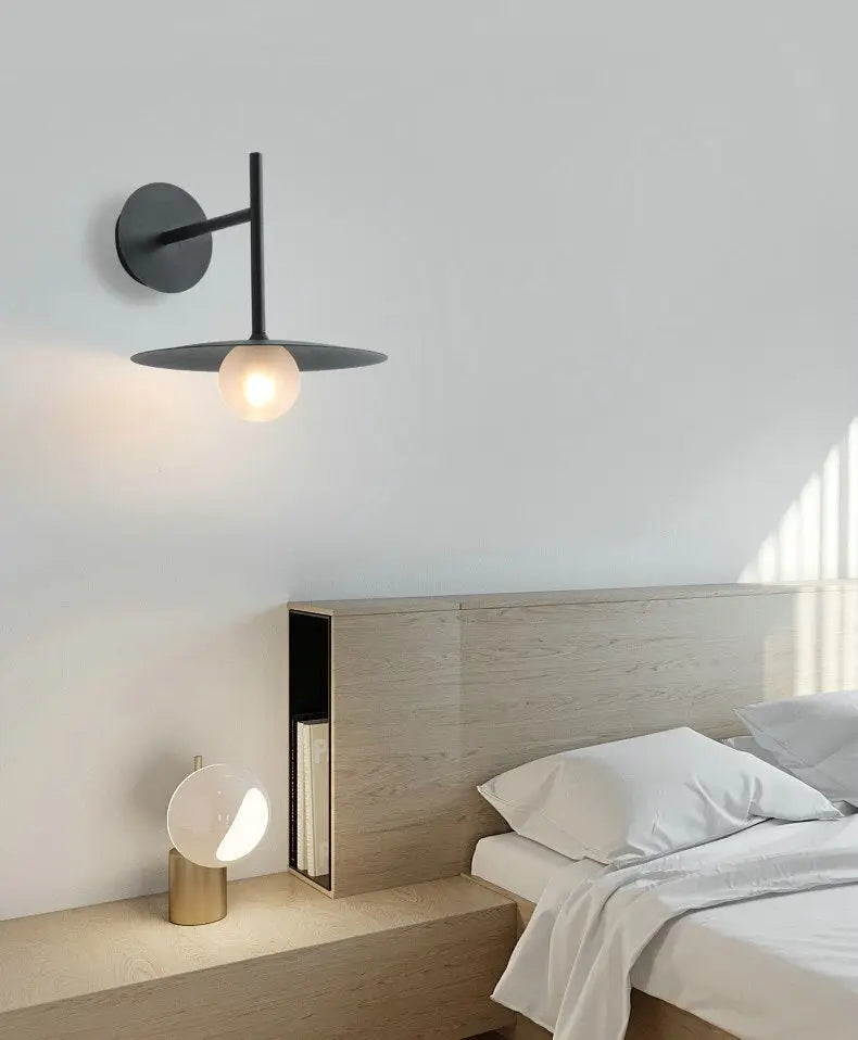DecorBites™ modern bedside wall light in black minimalist design with circular base and frosted glass globe bulb
