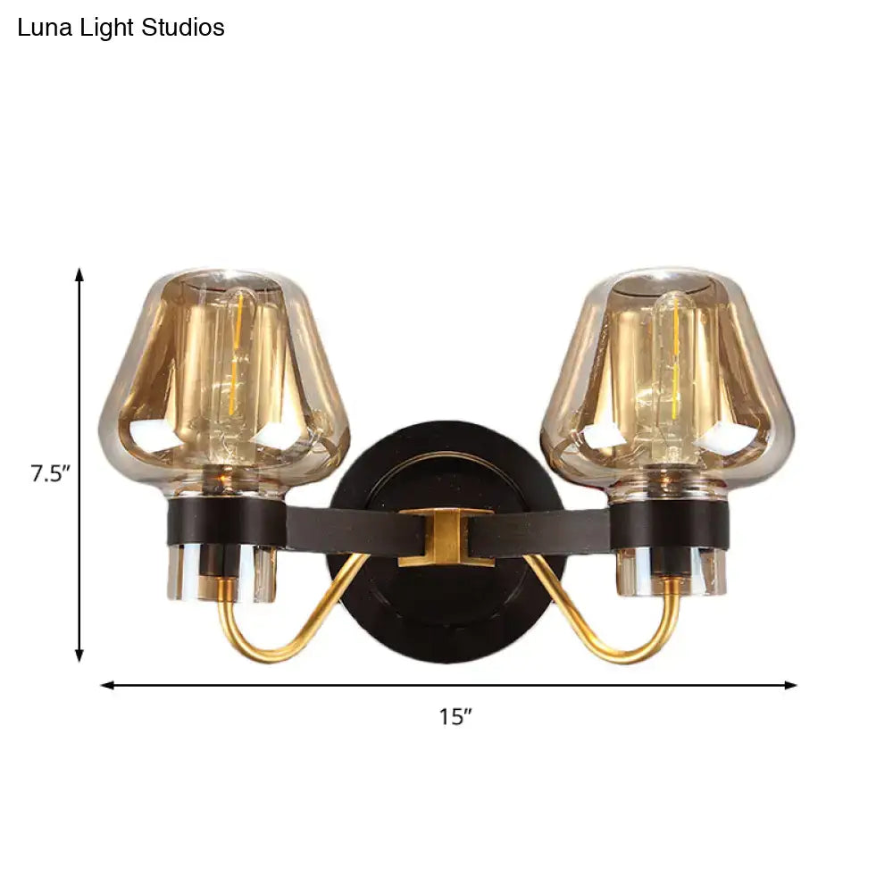 Modern black and gold two-light mushroom sconce light fixture with amber glass shades for living room use