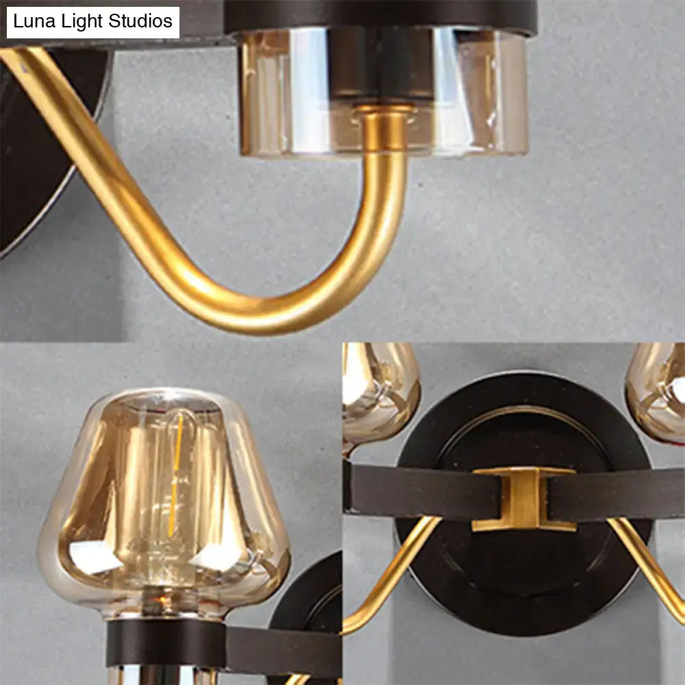 Modern black and gold mushroom sconce light fixture with amber glass shades and curved brass arms for living room