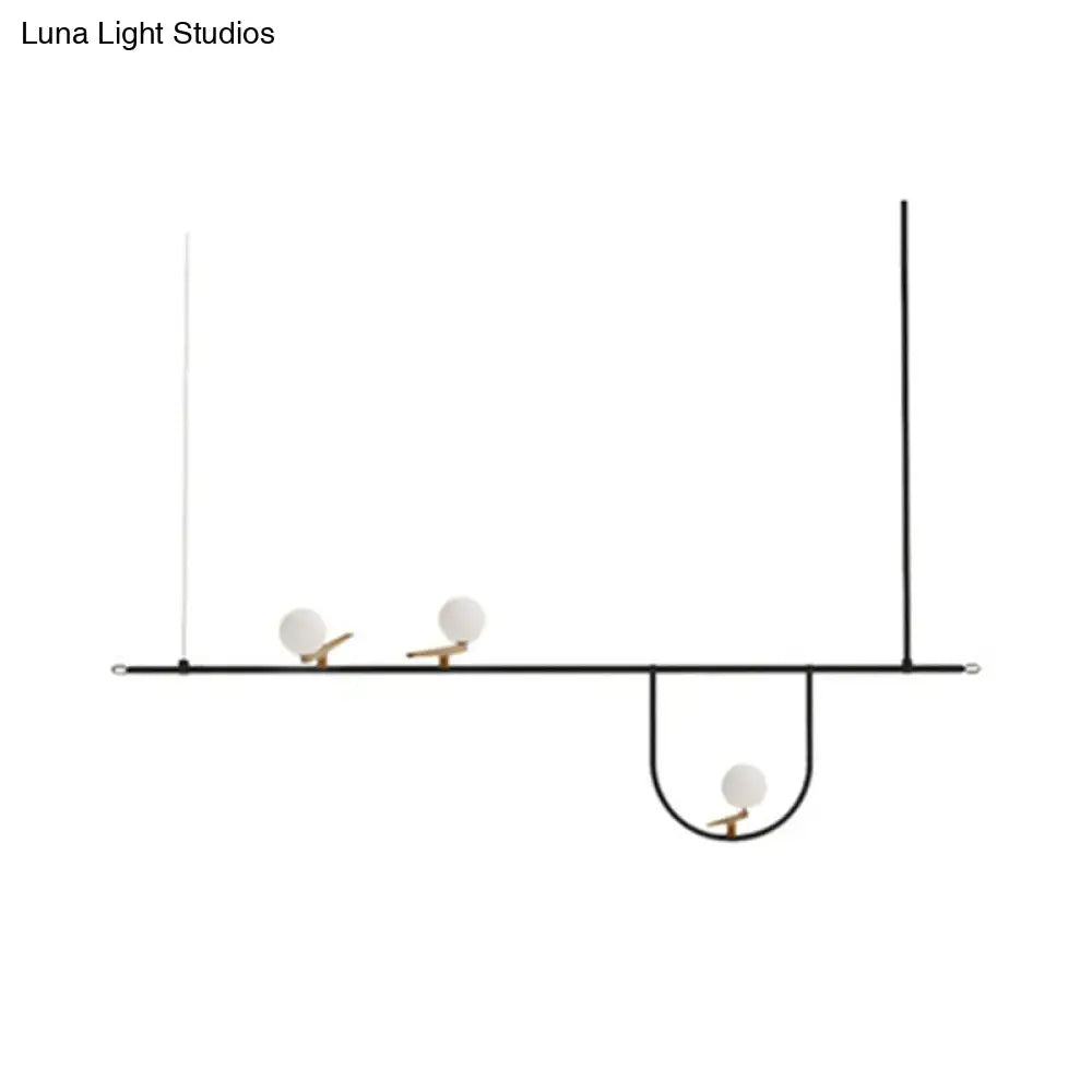 Minimalist black metal light fixture with three white glass sphere shades and cream accents for glass sphere island lighting