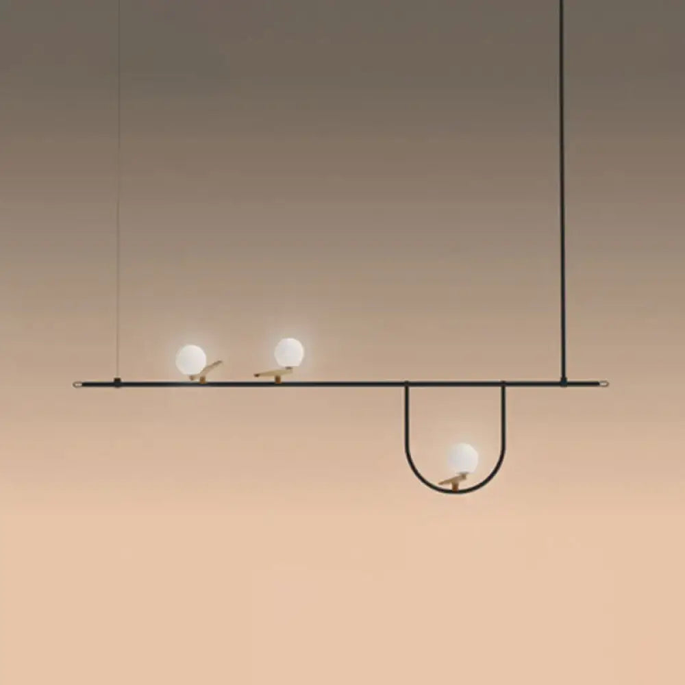 Modern black metal light fixture with three frosted glass sphere island bulbs and cream accents for ceiling mounting