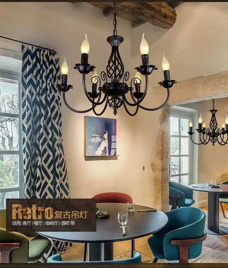 Modern black iron chandelier with ornate scrollwork and five lit candle bulbs for living room by DecorBites