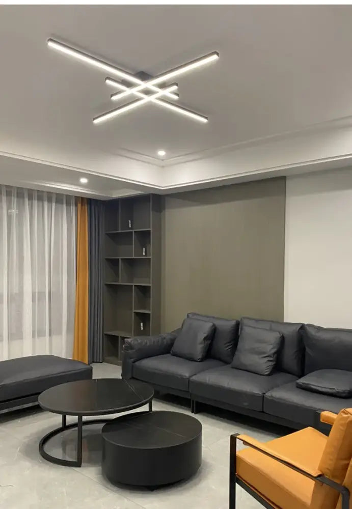 Modern black leather sofa with matching cushions beneath a sleek black chandelier square for bedroom and living room