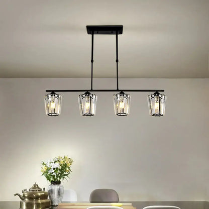 Black metal island chandelier with four clear glass candle-style shades and cylindrical crystal shade design