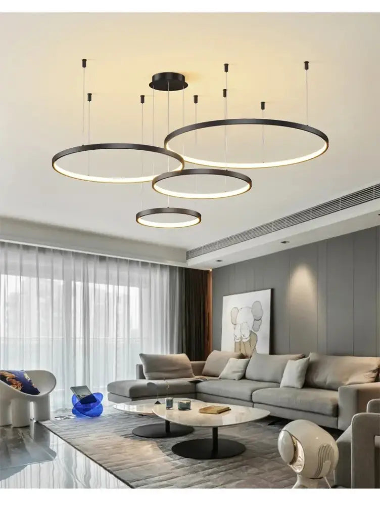 Modern black pendant light with circular illuminated rings hanging in living room from decorbites dimmable series