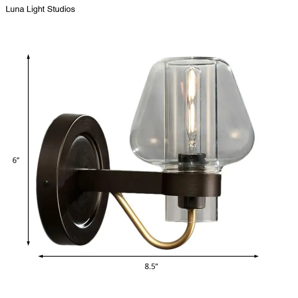 Modern black and brass wall sconce with glass mushroom shade featuring a dark bronze base and clear glass filament bulb