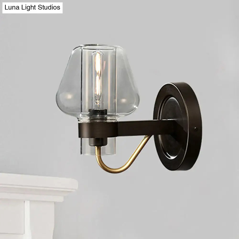 Modern black and brass wall sconce with glass mushroom shade featuring a clear glass and exposed filament bulb