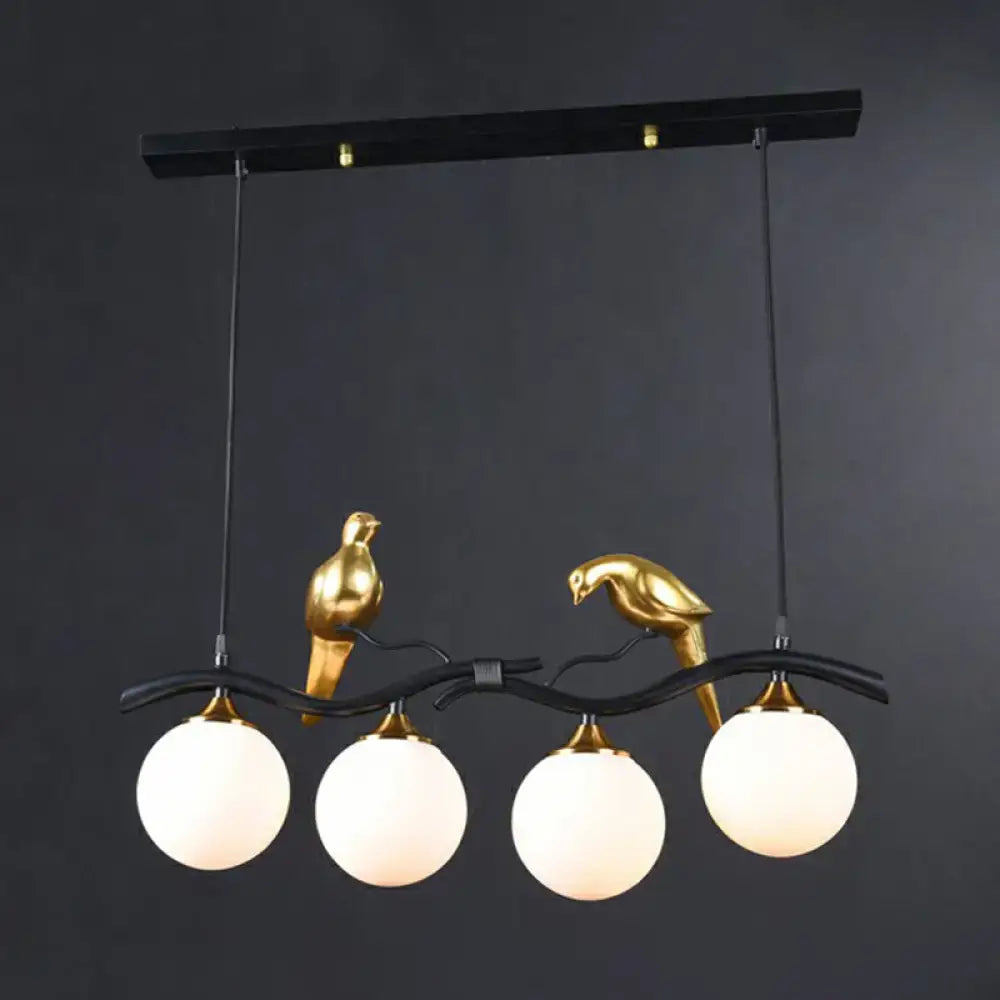 DecorBites modern black and gold bird-themed metal island pendant light with four frosted glass globe bulbs for dining room