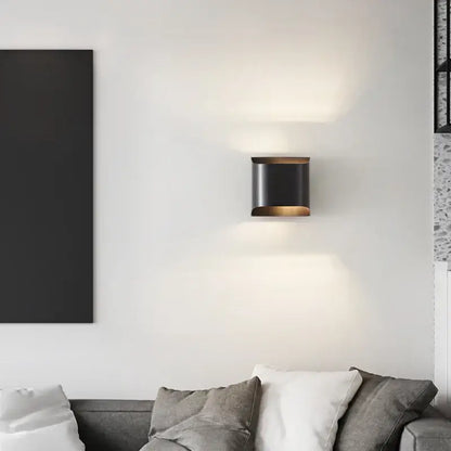 Black cylindrical decorbites wall lamp with warm glowing light and modern brass led accents for stylish interior lighting
