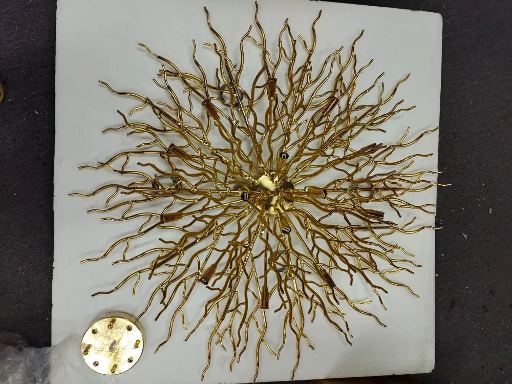 Golden intricate metal chandelier with branching arms and central hub resembling decorbites™ modern chrome chandelier with crystal raindrops