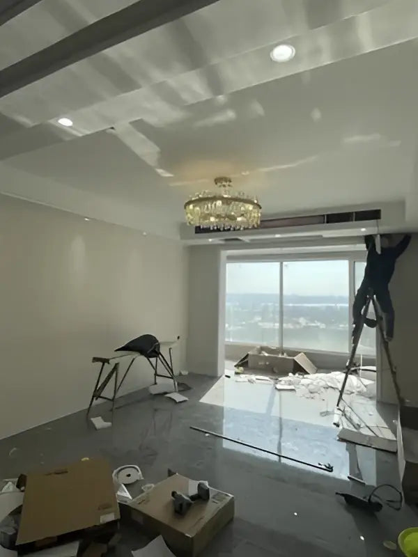 A gold crystal chandelier with golden chrome accents hangs in a dining room from DecorBites™ modern lighting collection