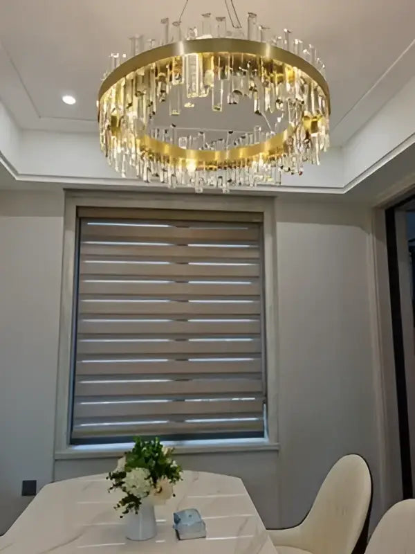 Gold-toned crystal chandelier with dangling strands in golden chrome for modern dining room by decorbites