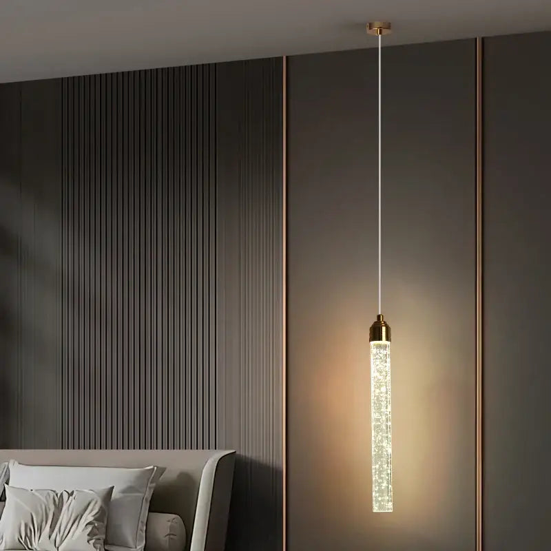 Decorbites modern crystal pendant light with gold fixtures featuring a cylindrical glass body filled with crystals