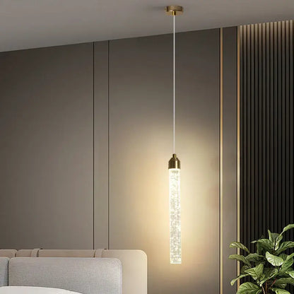 DecorBites™ modern crystal pendant light with cylindrical glass body and gold fixtures suspended by white cord