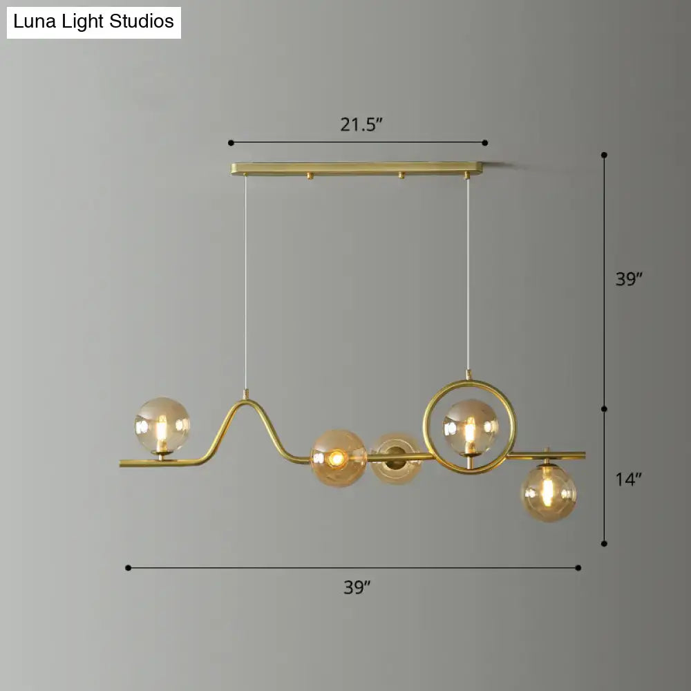 DecorBites modern curve island ceiling light with gold-toned metal arms and glass ball shades for dining room
