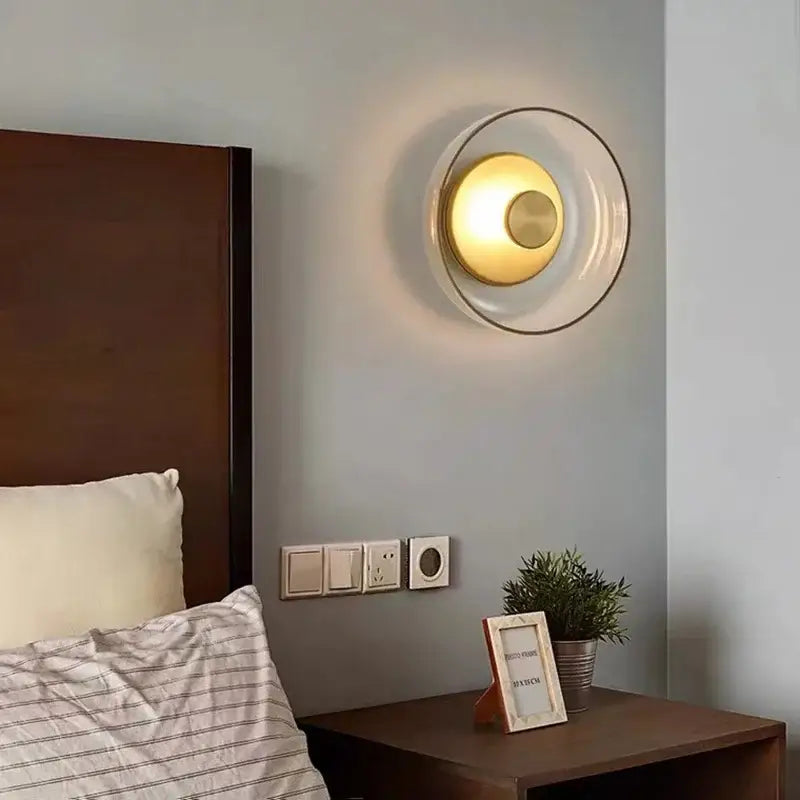 Decorbites™ modern led wall light featuring a circular design with clear glass, brass accents, and warm golden glow