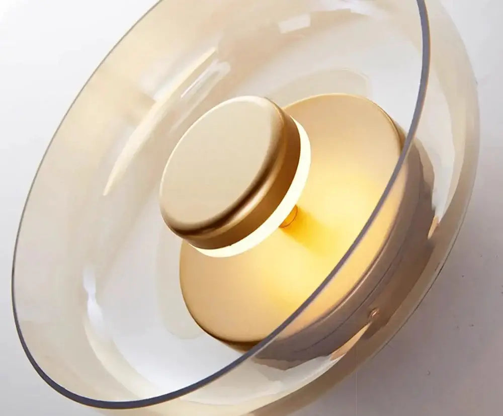 DecorBites™ modern glass LED wall light features a translucent amber glass pendant with a gold-toned base