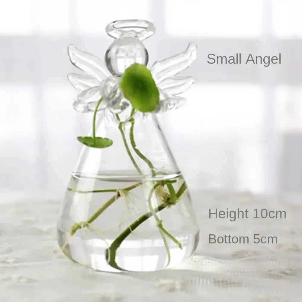 Clear glass angel-shaped glass vase terrarium with transparent wings and halo holding green aquatic plants and water