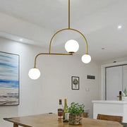 Gold-toned modern global bedroom chandelier with three yellow white frosted glass globes and LED hanging light kit