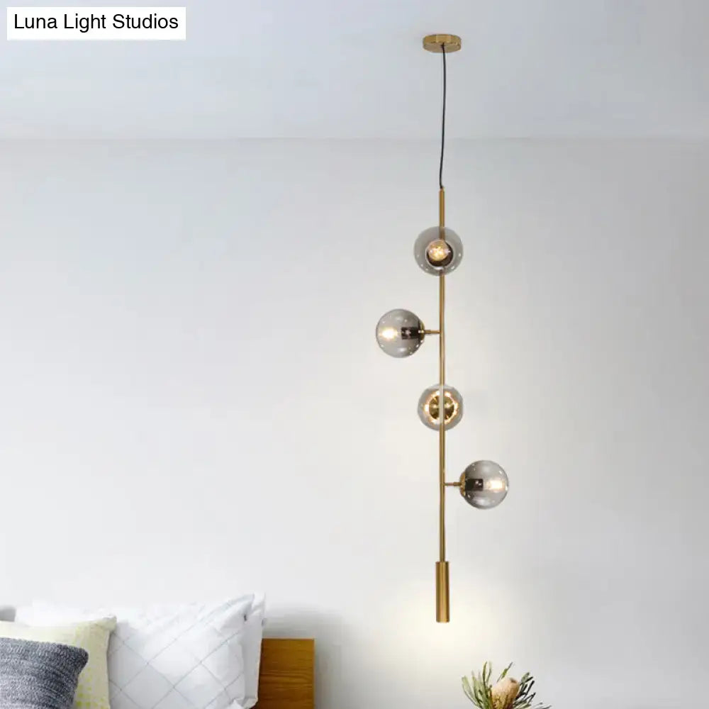 Decorbites modern gold linear chandelier with four gray glass shades on a brass metal hanging fixture