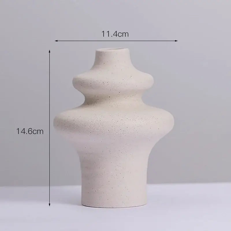 Cream-colored ins style ceramic spiral vase with a textured speckled surface and tiered organic curves by DecorBites