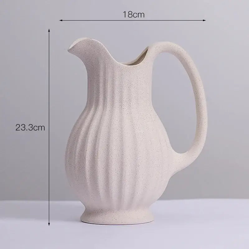 Cream-colored ins style ceramic spiral vase with vertical ribbed texture and smooth curved handle by DecorBites