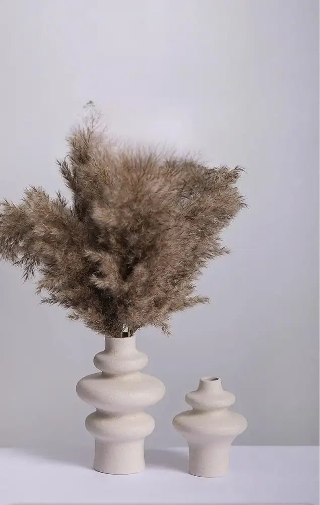 Cream-colored ins style ceramic spiral vase by decorbites holding brown pampas grass bouquet
