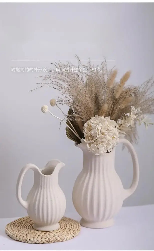 Cream-colored ins style ceramic spiral vase with vertical ribbed texture and handle filled with pampas grass and hydrangeas