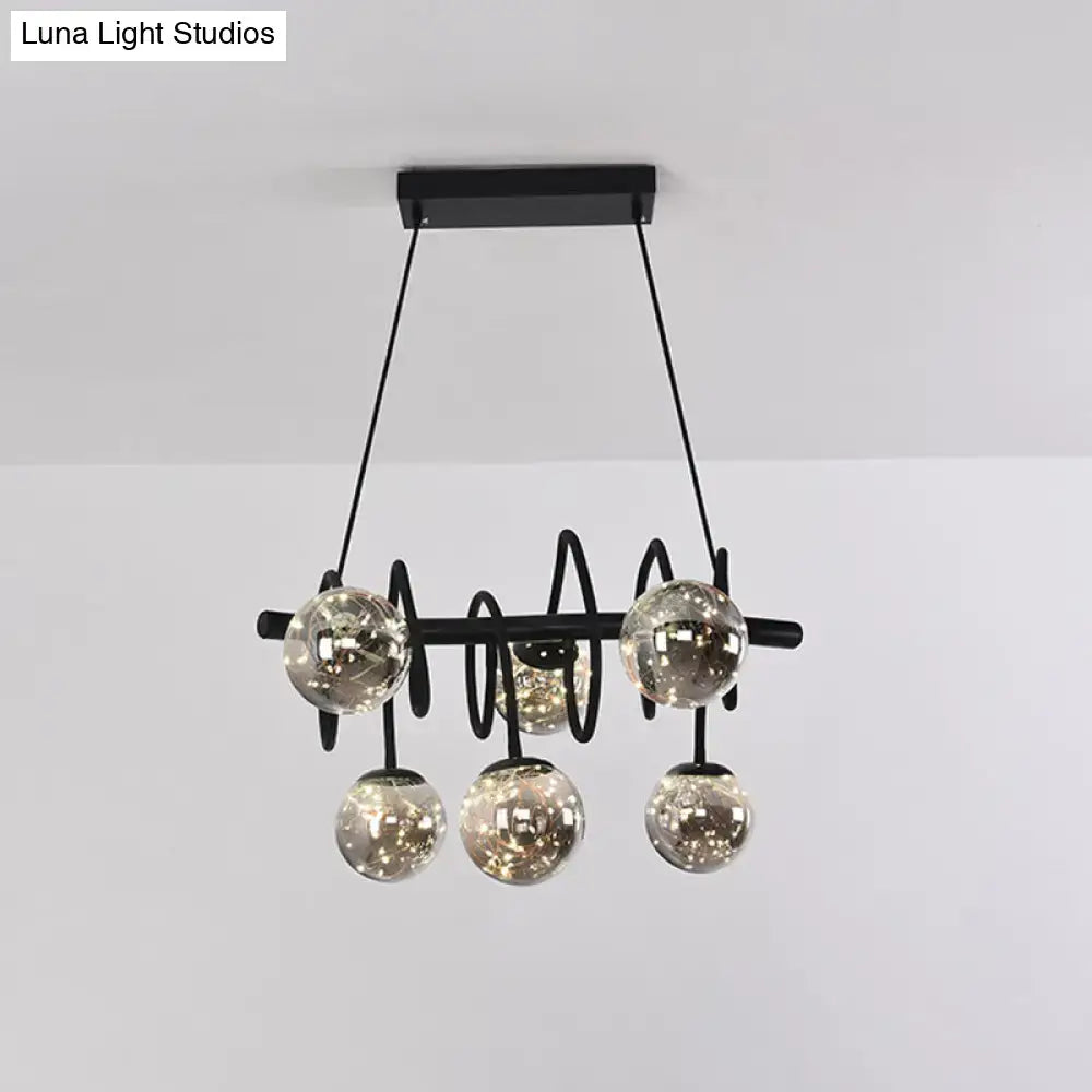 Modern black metal chandelier with five smoke gray glass shade globes suspended by thin cords for dining room lighting