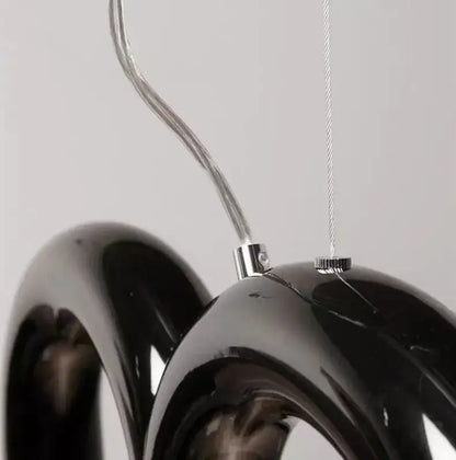 Black glossy glass pendant light with chrome hardware and curved wire suspension from decorbites oblure arch chandelier