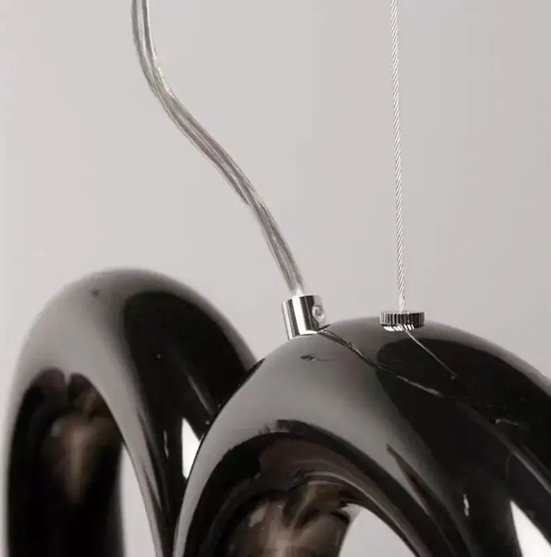 Black glossy glass pendant light with chrome hardware and curved wire suspension from decorbites oblure arch chandelier