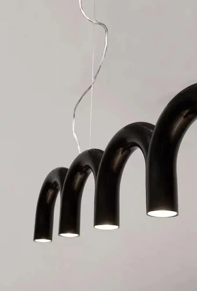 Black curved pendant light with warm glow and sleek modern design in DecorBites™ oblure arch chandelier series